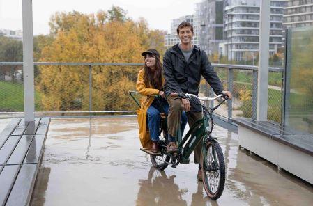 Un couple sur un vélo cargo longtail Nébula dans un parc