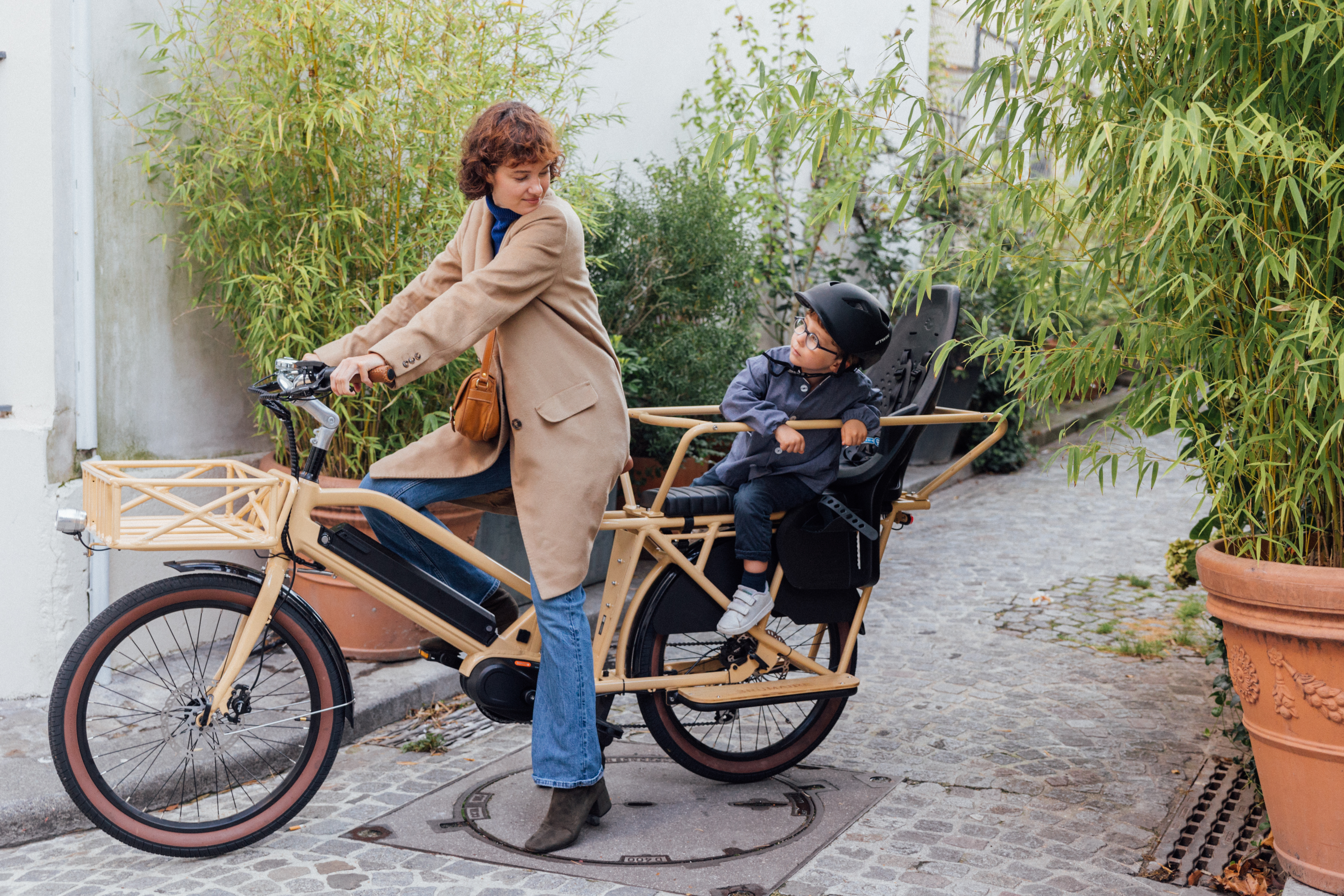 Une femme avec son fils sur le siège enfant sur un vélo électrique longtail Nébula