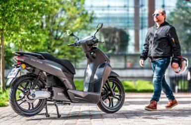 Un homme qui avance vers son scooter électrique