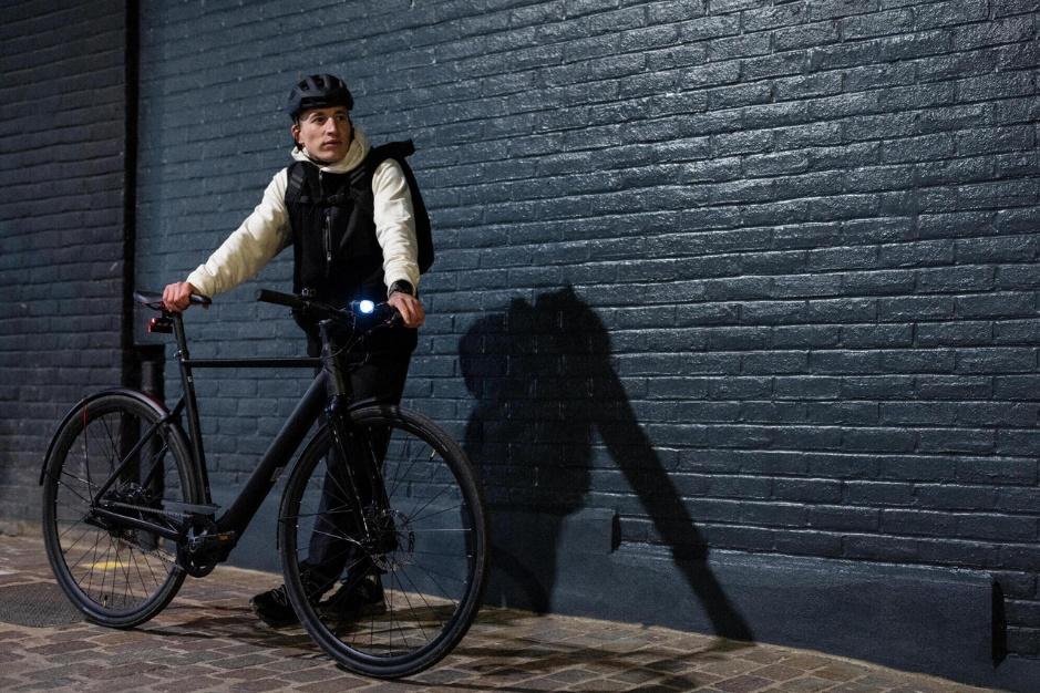 Un homme qui attend à côté de son vélo dans une ruelle