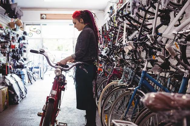 Une vendeuse de magasin de vélo qui replace la selle d'un vélo