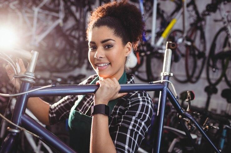 Une vendeuse d'un magasin de vélo avec un vélo sur son épaule