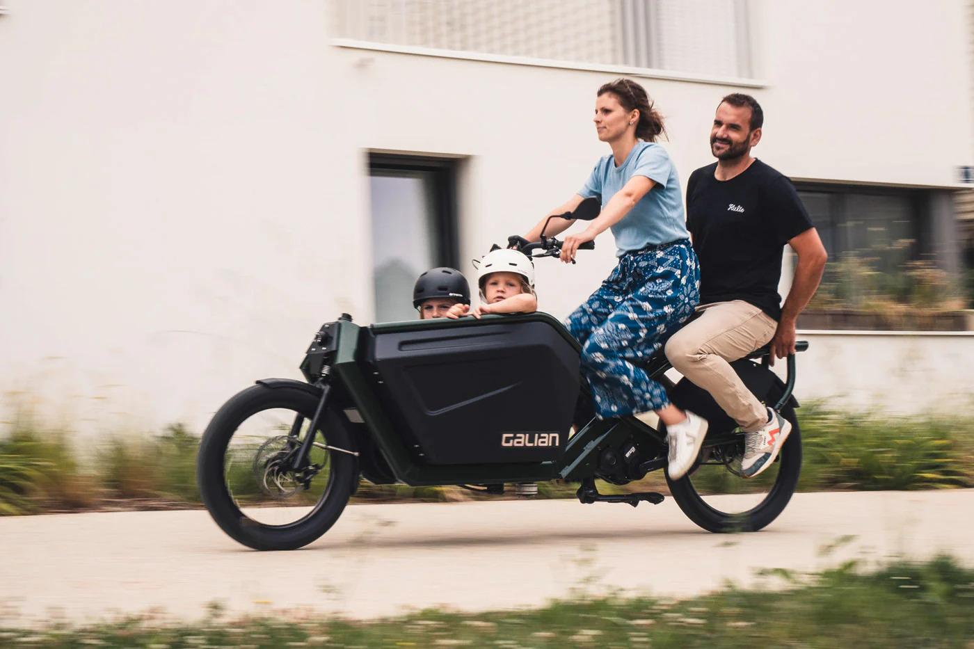 Un couple avec leurs enfants dans un vélo cargo