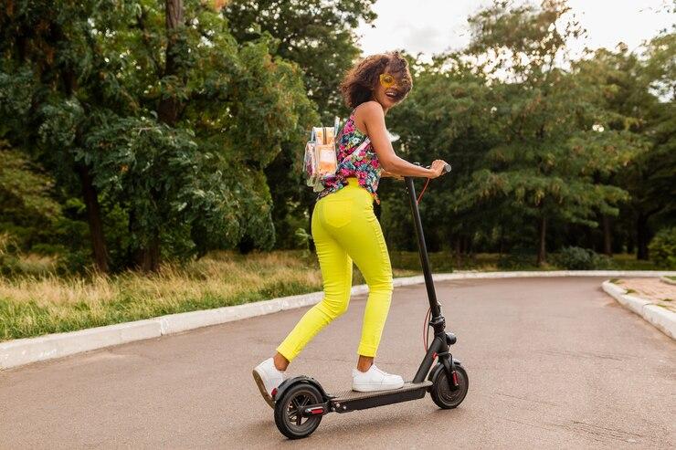 Une femme sur une trottinette électrique en pleine rue