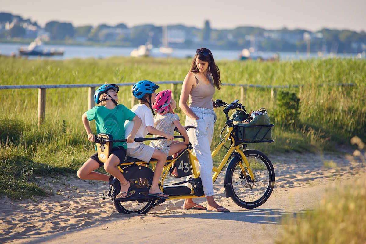 Une famille sur un vélo électrique longtail jaune