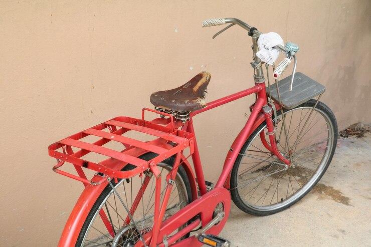 Un vélo longtail rouge posé contre un mur